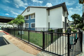 an apartment building with a black fence in front of it